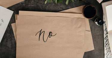 Say No - Image of the word "no" written on a plain brown sheet of paper