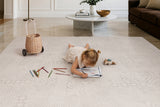 Child drawing on the Toddlekind Aria Playmat with colored pencils, featuring an elegant neutral  design perfect for family living spaces.
