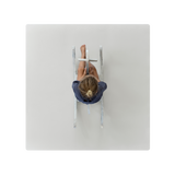 A playmat in a stone color, presented from a top-down view showing a baby lying on it. Alt Img