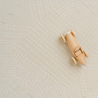 Overhead view of assembled toddlekind baby toddler foam modern designer puzzle play mat haven deco ecru with visible seams and wooden toy.