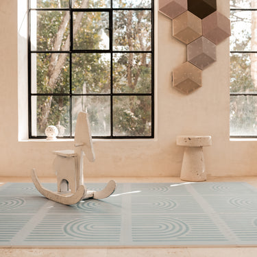 Minimal interior scene with rocking toy placed on the toddlekind baby toddler foam modern designer puzzle play mat haven linear mineral