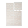 Interlocking foam tiles arranged in a grid with one corner lifted showing edges of the toddlekind baby toddler foam modern designer puzzle play mat haven linear linen.