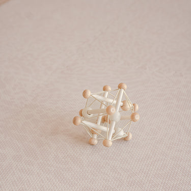 Minimal wooden toy placed on textured surface of toddlekind baby toddler foam modern designer puzzle play mat haven wild dune.