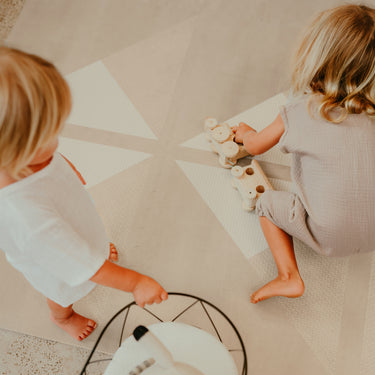 Top view of toddlers playing with wooden toys and stroller on toddlekind baby toddler foam modern designer puzzle play mat haven kyte mocha.
